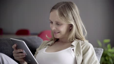 Happy-pregnant-woman-using-tablet